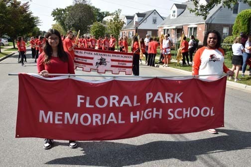 Students holding the school banner await the parade.