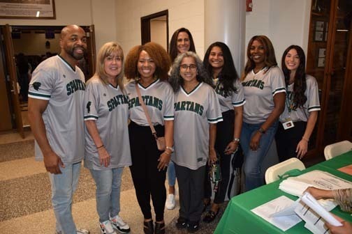 Students and teachers smiling together.