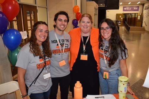 Students and teachers smiling together.