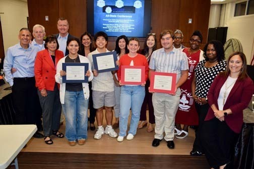 Board members with students holding awards.