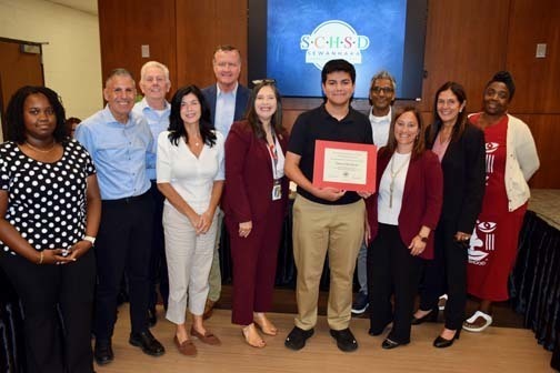 Board members with students holding awards.
