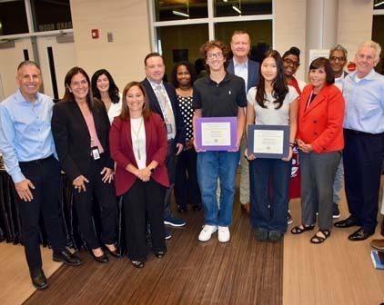 Board members with students holding awards.