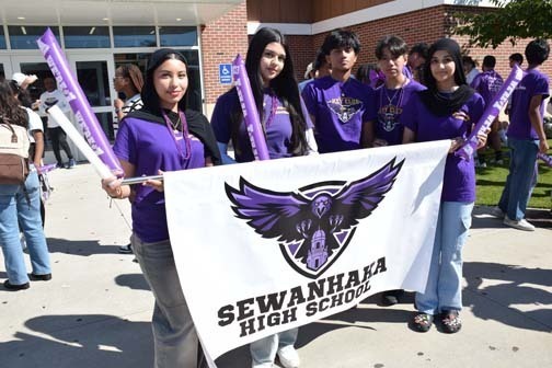 Students with school banner pose for photo before the homecoming parade. 