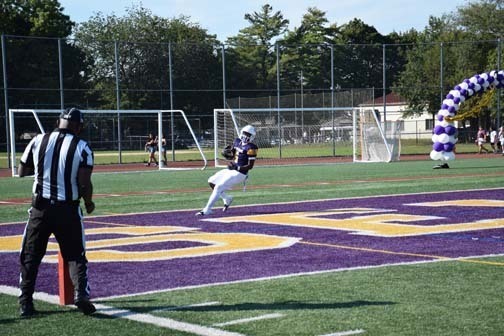 Football player scores a touchdown.