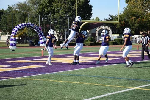 Football player scores a touchdown.