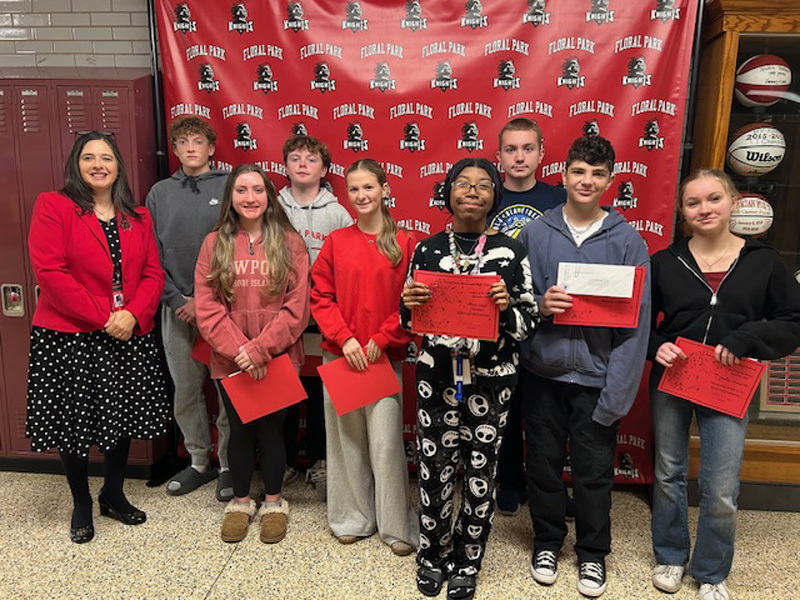 students in hallway with red papers