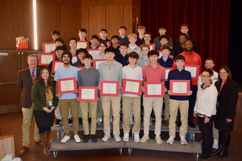 A group of young adults, stand in a theater's front stage area