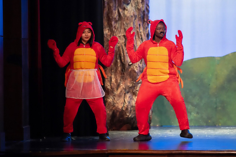 students perform in a play onstage