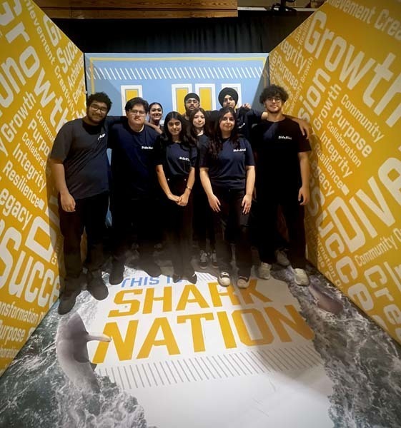 Students standing in yellow and blue room.