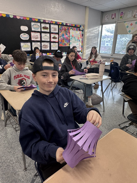 student with purple paper craft