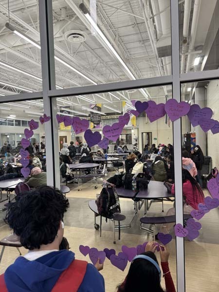 Students and staff dressed in purple to commemorate P.S. I Love You Day on Feb. 13, writing messages of kindness on hearts near the cafeteria. 