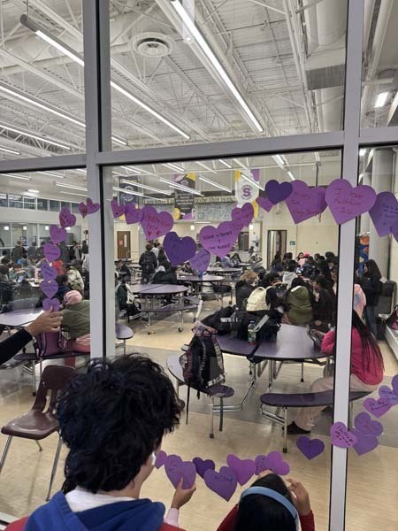 Students and staff dressed in purple to commemorate P.S. I Love You Day on Feb. 13, writing messages of kindness on hearts near the cafeteria. 