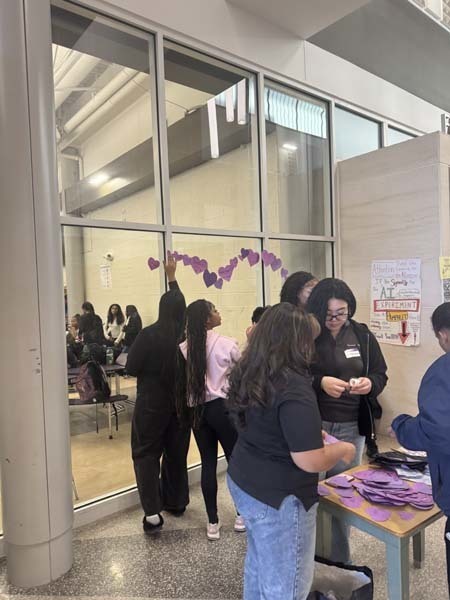 Students and staff dressed in purple to commemorate P.S. I Love You Day on Feb. 13, writing messages of kindness on hearts near the cafeteria. 