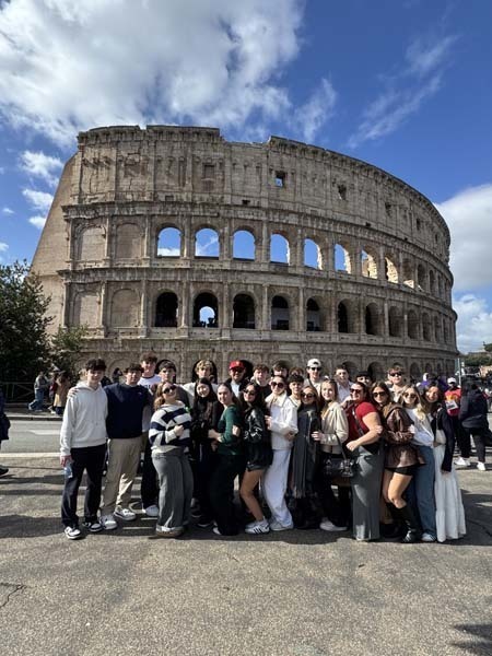 Students standing outside historic building.