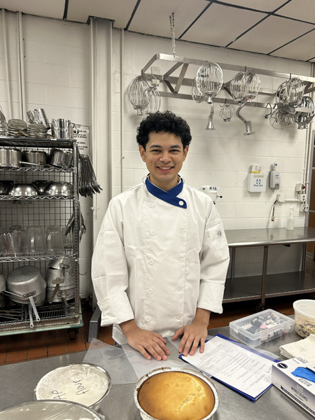 Three young women in red blazers with patches stand smiling in front of a SkillsUSA Long Island Area VI backdrop, exuding pride and confidence.