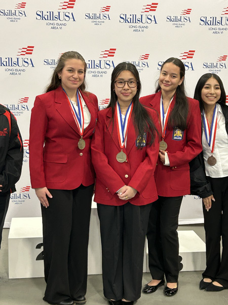 Three young women in red blazers with patches stand smiling in front of a SkillsUSA Long Island Area VI backdrop, exuding pride and confidence.