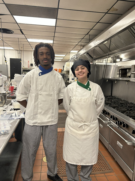 Three young women in red blazers with patches stand smiling in front of a SkillsUSA Long Island Area VI backdrop, exuding pride and confidence.