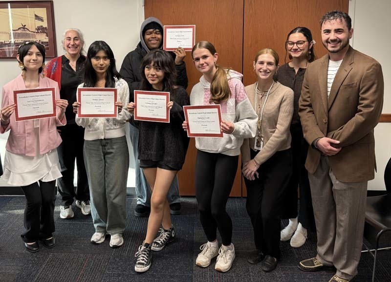 Student artists holding awards.