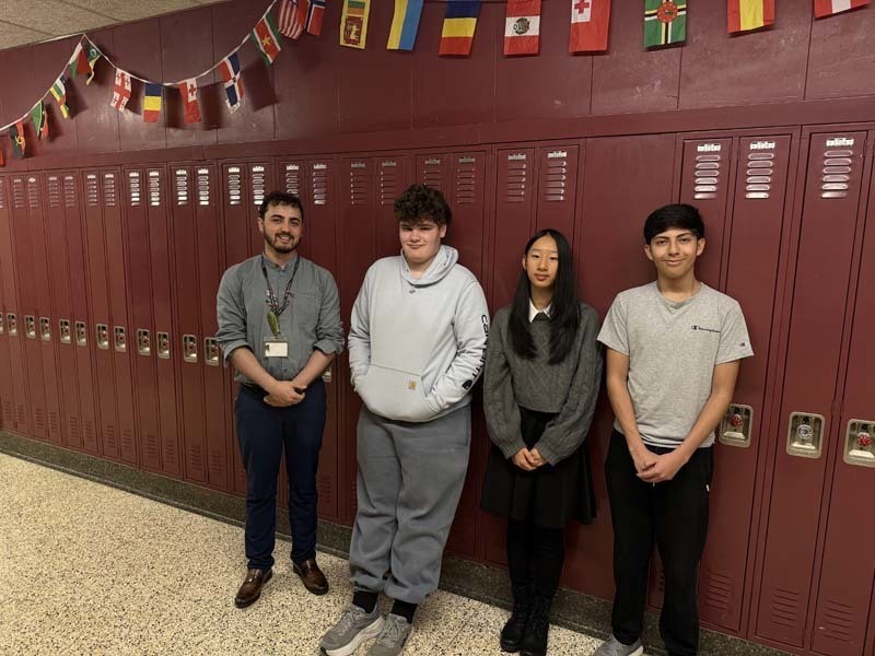 Students  standing in front of lockers. 