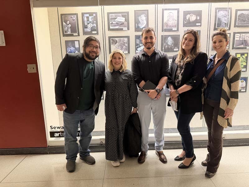 Students and teachers in front of showcase.