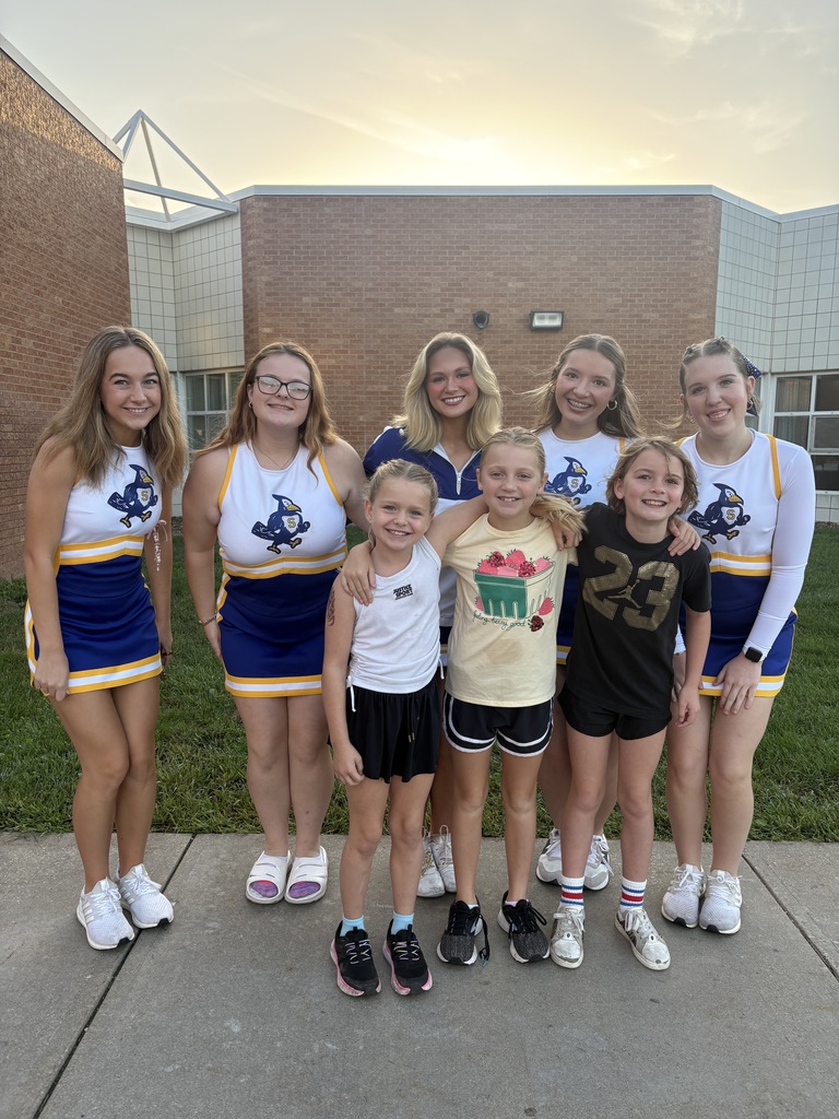 Cheerleaders and students smiling.