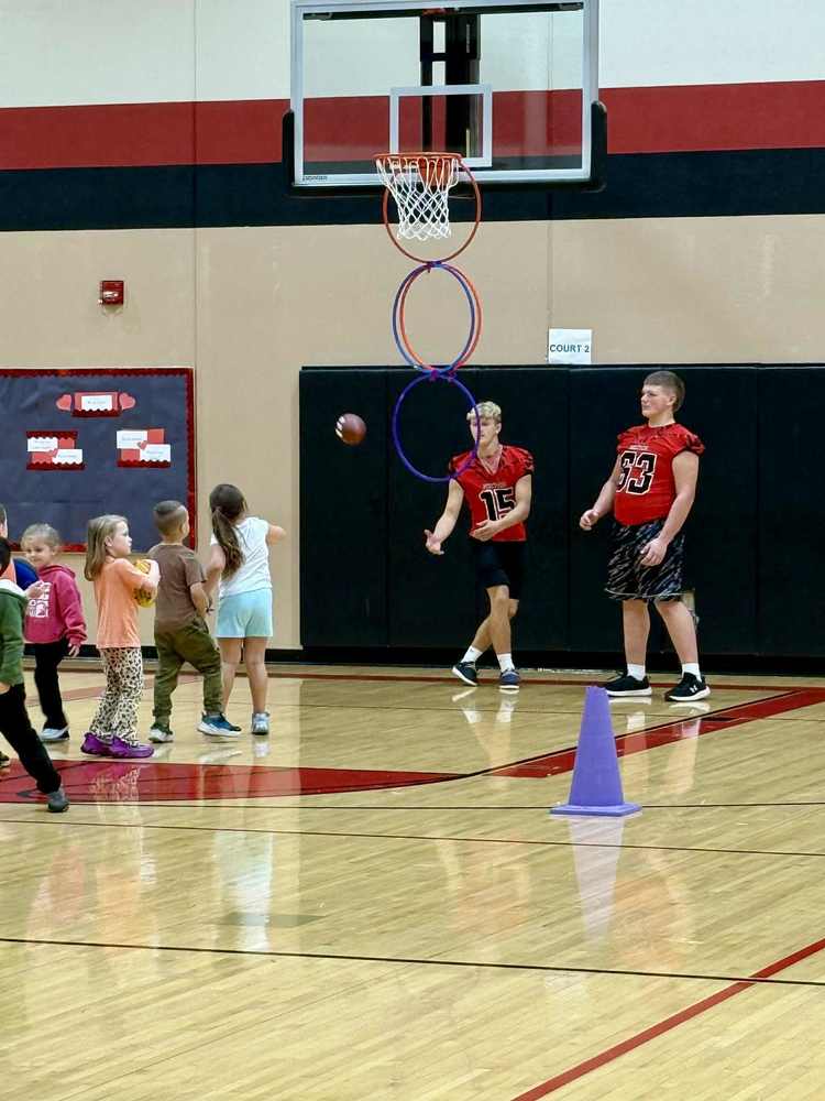 Football players interact with Hillcrest Students during gym.