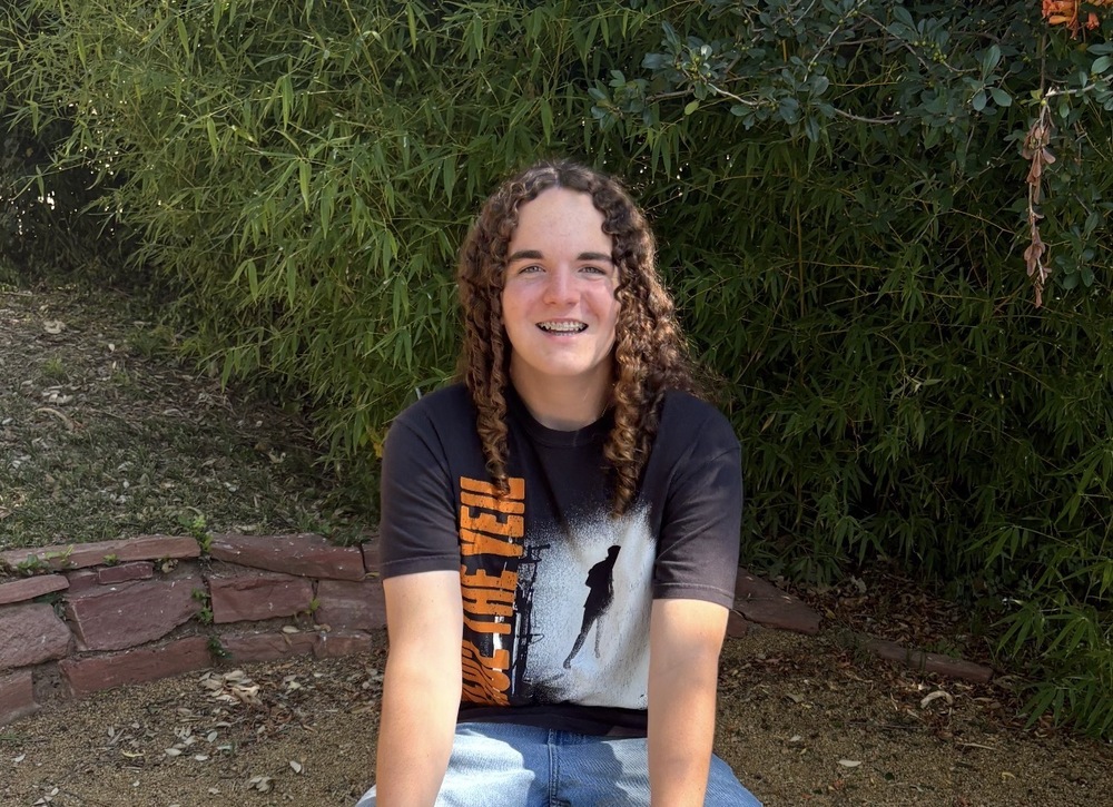 image of teen boy sitting outside
