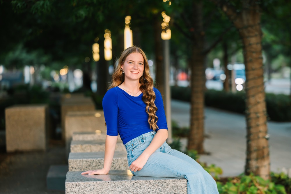 girl in blue shirt sitting outside