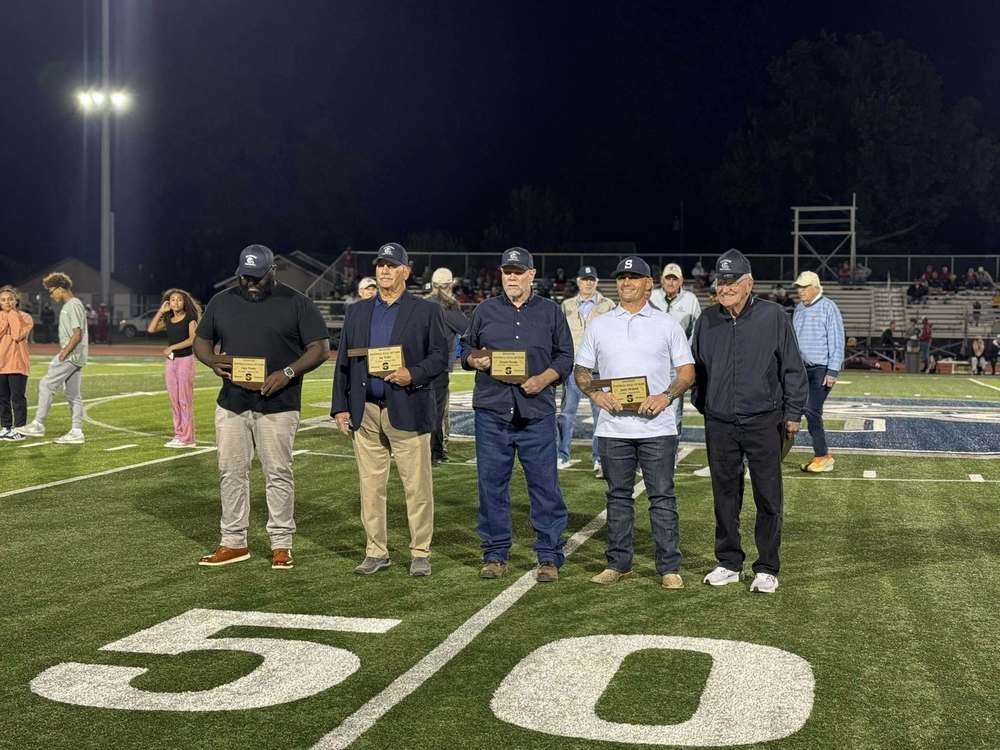 Image of five men on football field