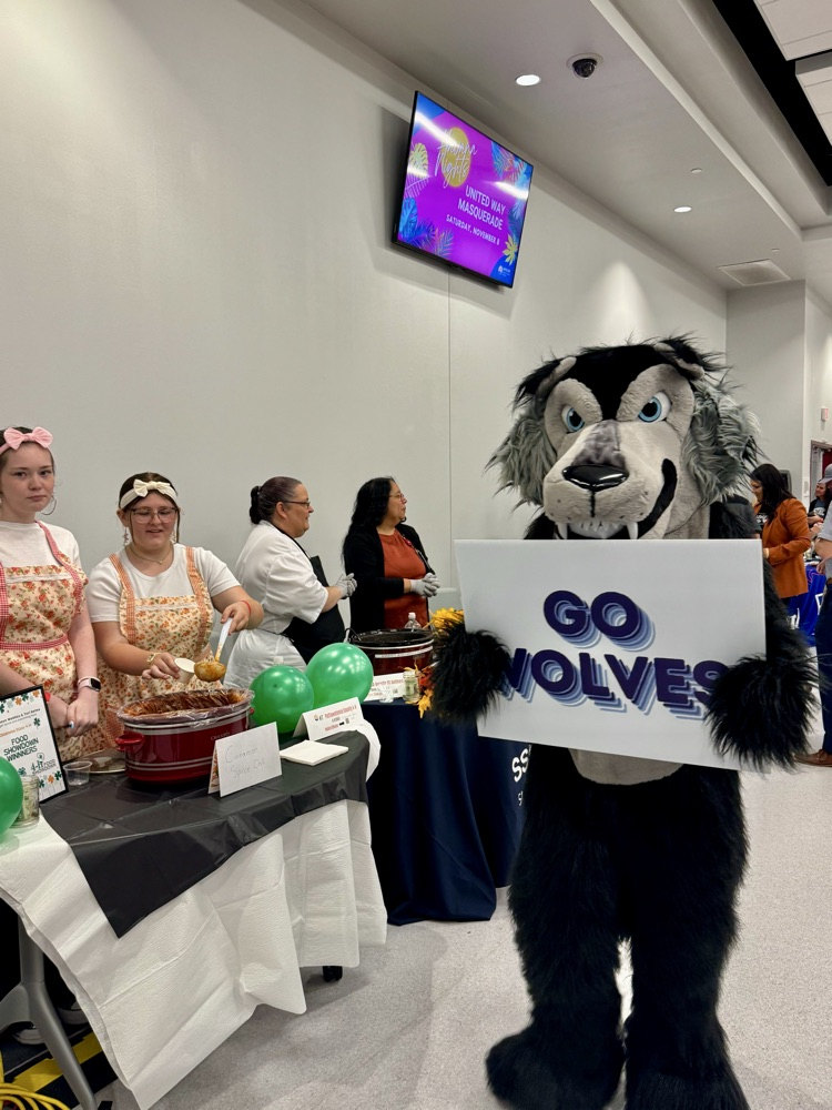 wolf mascot holding sign
