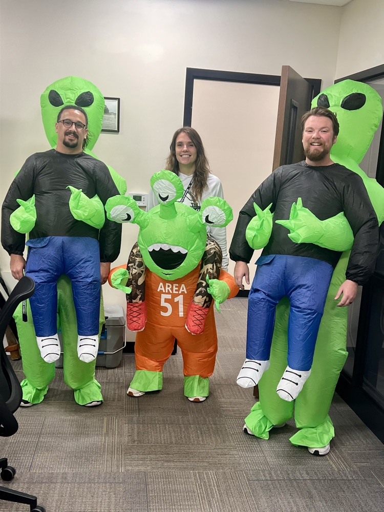 three adults in alien costumes 
