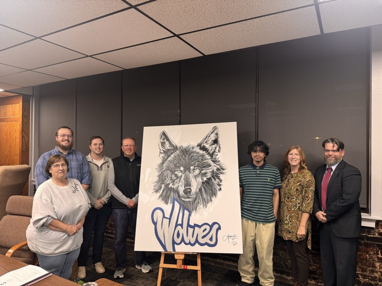 group of adults standing with wolf painting
