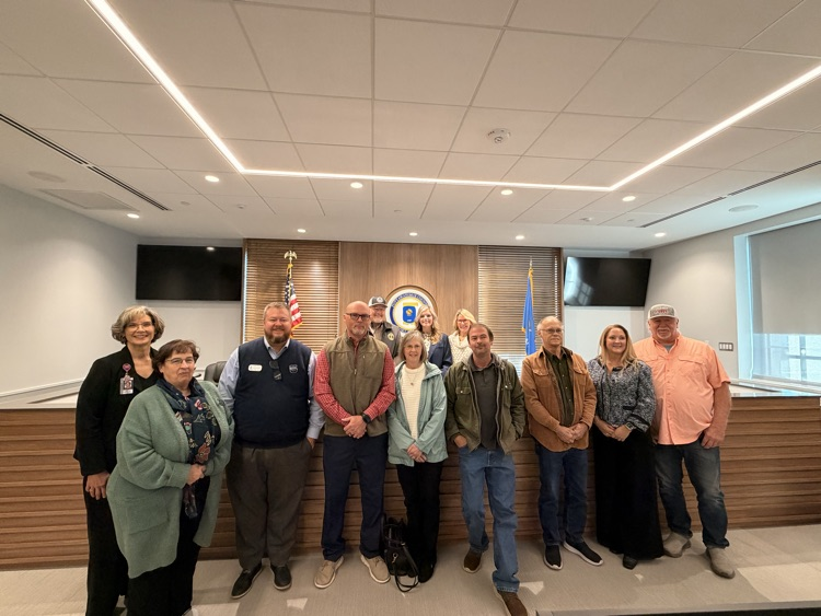 group of adults standing in commission chambers