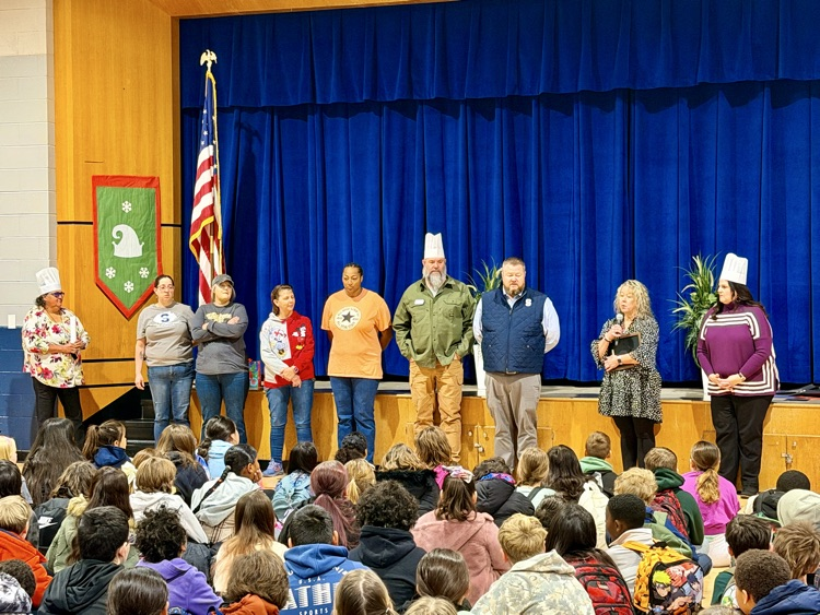 adults standing in elementary gym