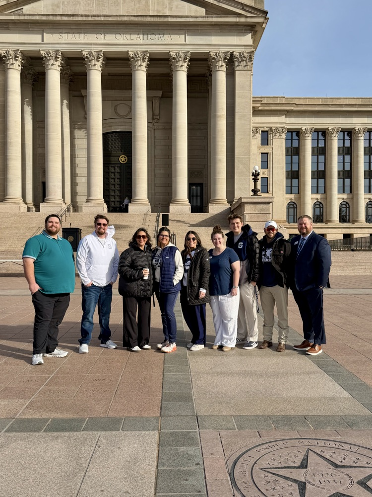 group of adults standing in front of Capitol