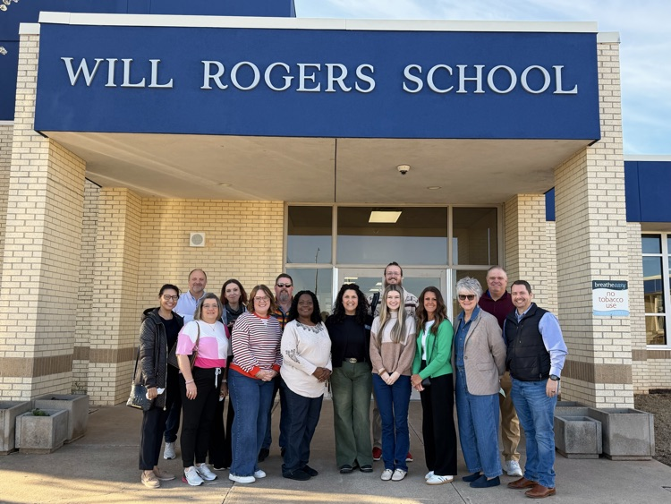 adults standing in front of school