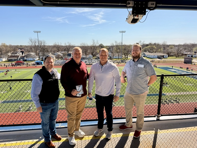 men standing overlooking football field