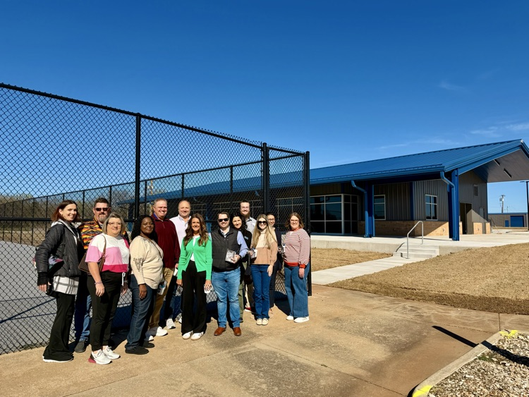 group of adults by tennis court