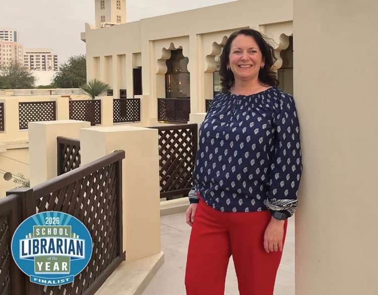 woman in blue shirt in front of white building