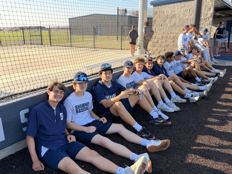 baseball players sitting on fence line 