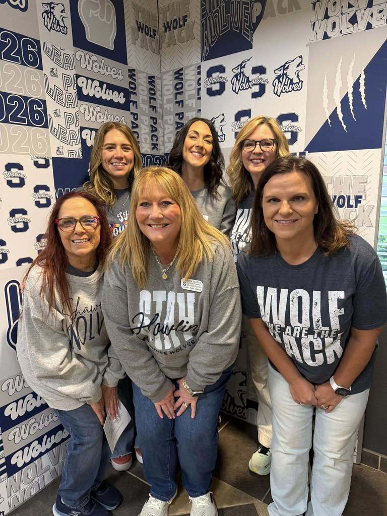 six adult women smiling in photo booth 