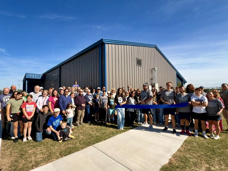 large group cutting ribbon outside