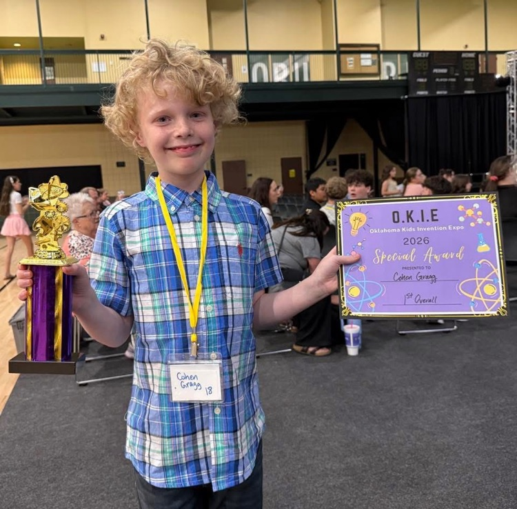 boy holding award and trophy