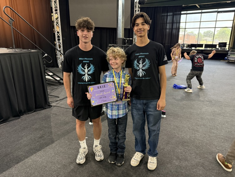elementary boy with two teenage boys smiling 