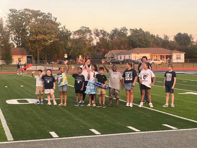 students waving on football field