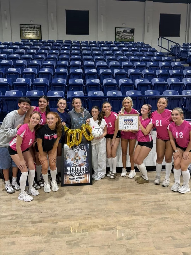 volleyball team in pink shirts on court