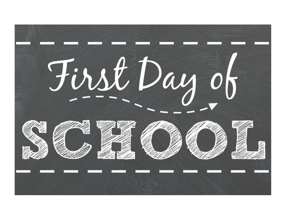Black board with word "First Day of School" written on it.