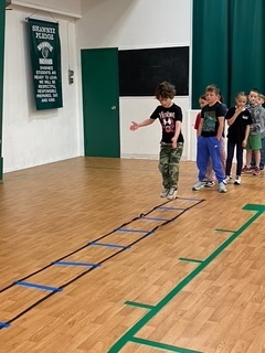 Young boy hoping through agility ladder.