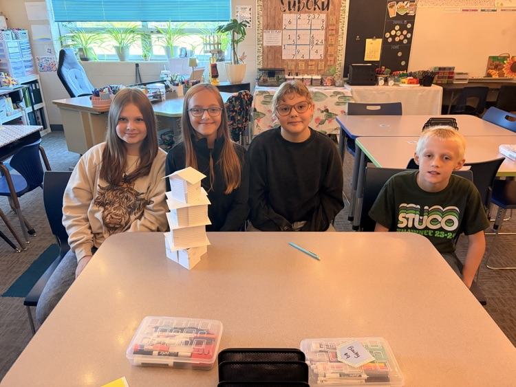 students building paper tower