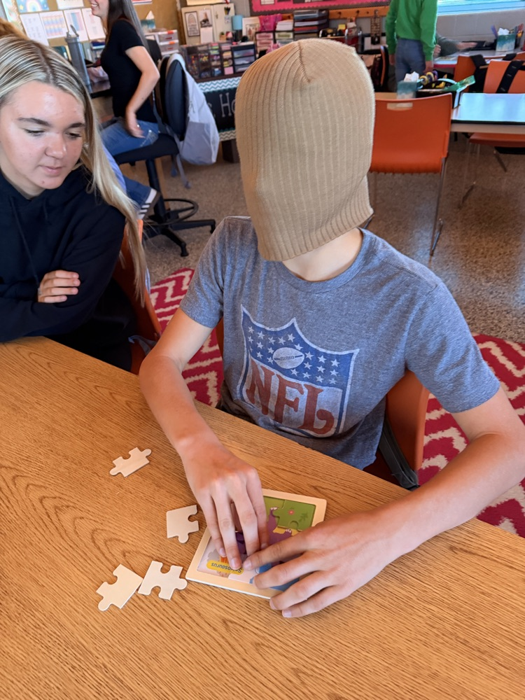 student putting together a puzzle while blindfolded